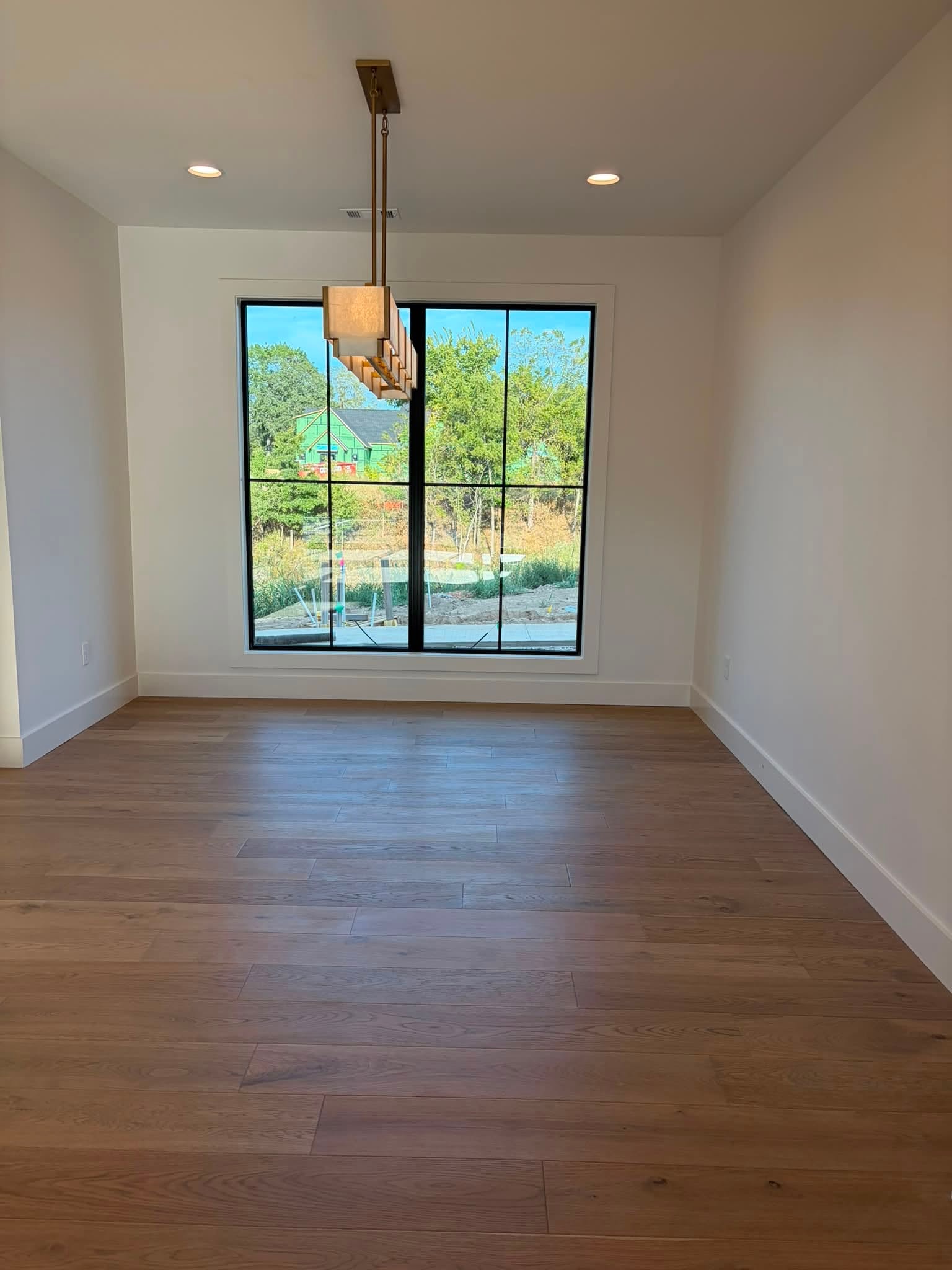 Final clean — bright dining room with large windows and hardwood floors